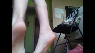 The soles of the girl who stretches out trying to take things on the shelf